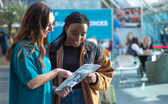 A University of Bradford student ambassador helping a visitor on an Open Day