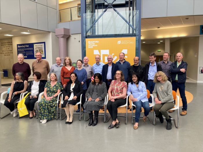 A photo of graduates from the class of 1983 Optometry reunion. The alumni are pictures in the Atrium, located in the University's Richmond Building.