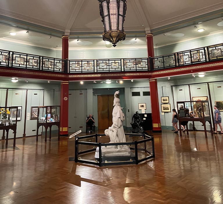 A statue in the middle of a museum hall.