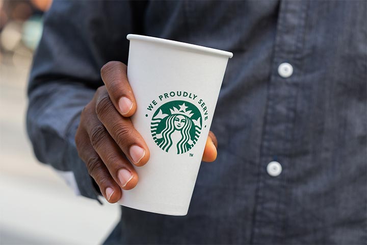 A student holding a cup of coffee.