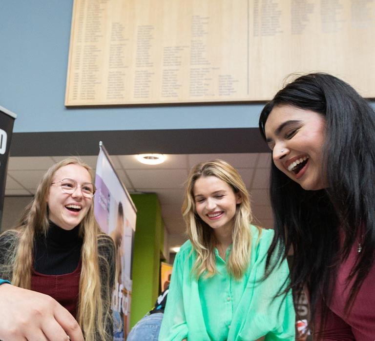 A group of student playing table top football and laughing.