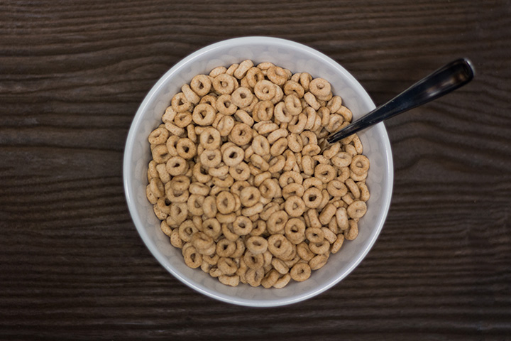 Loop shaped cereal in a white bowl with a spoon in it