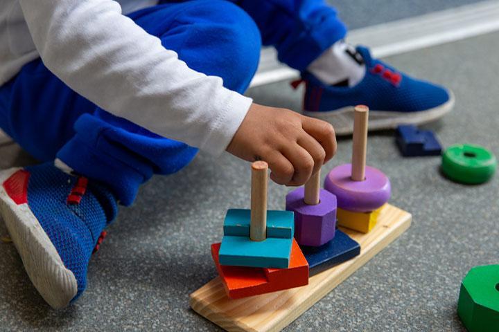 A child playing with wooden building blocks.