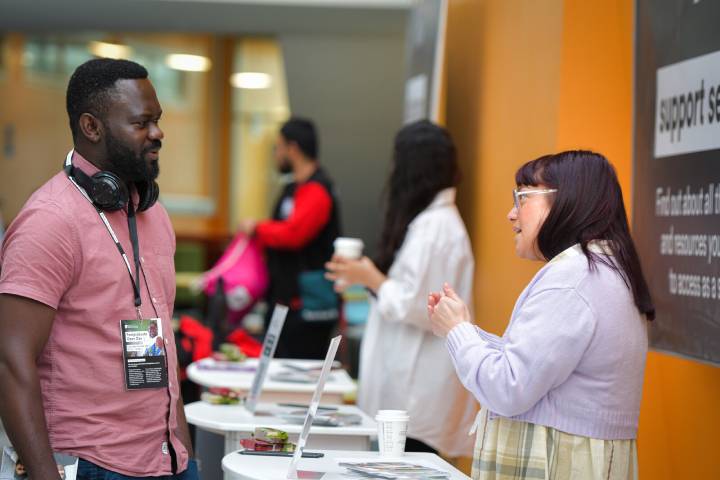 A student speaking to an academic at an event