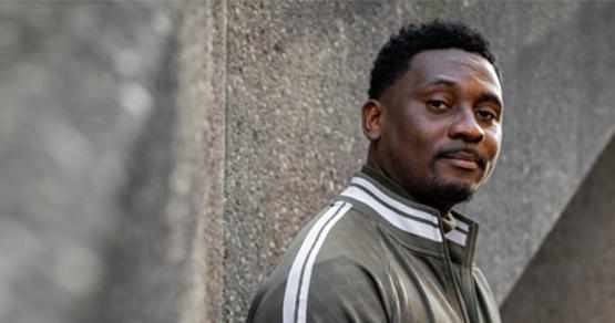 Alex, an international student who came to the University from Nigeria, posing in Library square on campus.