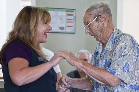 A staff member dancing with an older person. Copyright Cathy Greenblat photography.