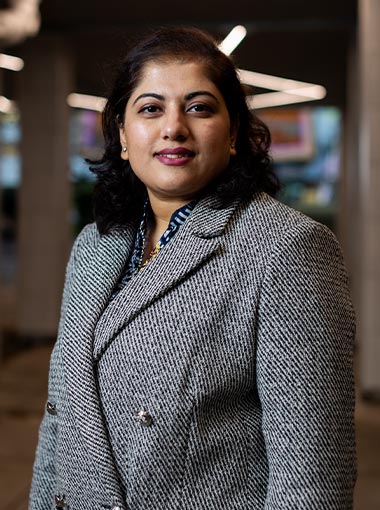 A student looking at the camera in front of a colourful background