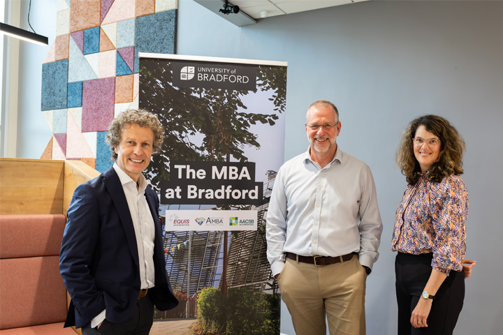 Ian Adams, Nick Snowden and Merel Olgers posing in front of an MBA Summit banner at the 2024 event.