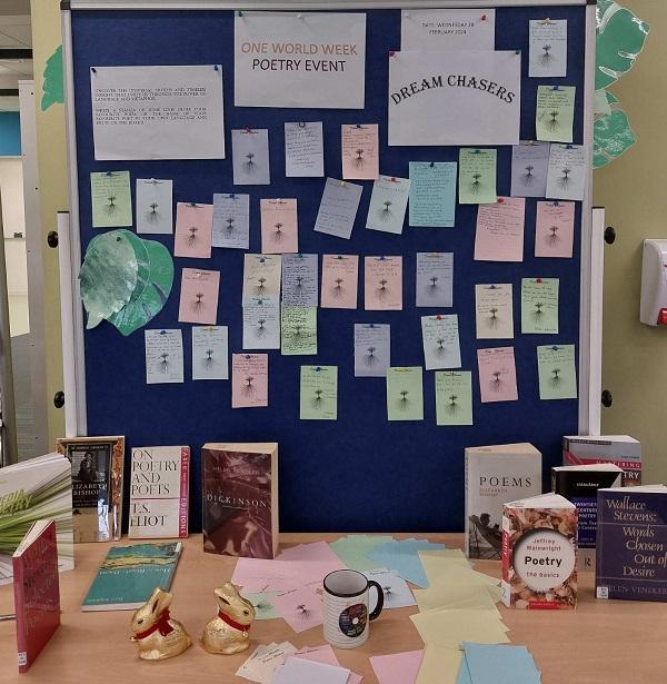 One World Week poetry event display with poetry books and poems from students.