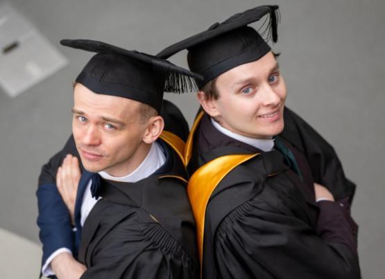 Two graduands looking into camera