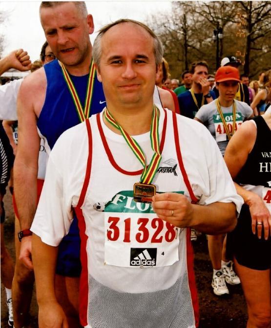 A person wearing a running vest with a medal around their neck