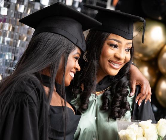 Two students celebrating graduation