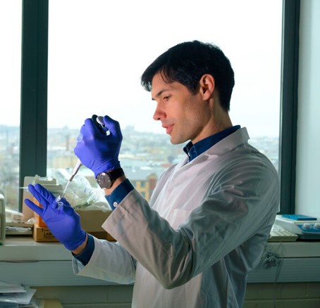 A pharmacology student operating a pipette