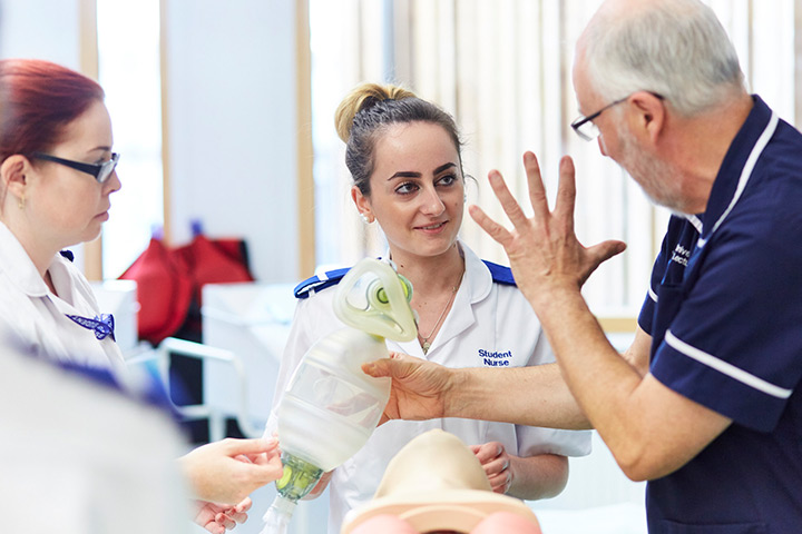A student nurse practicing CPR with a lecturer