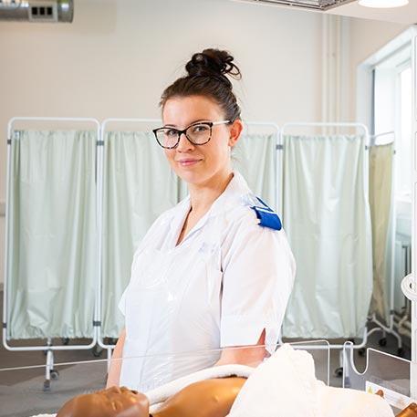 A student midwife smiling at the camera.