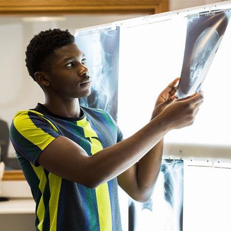 A student placing X-rays on a lightbox.