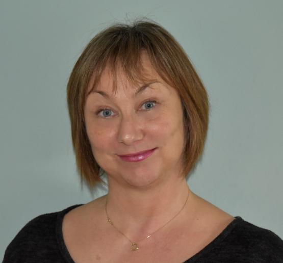 A woman with medium length hair looks into the camera.